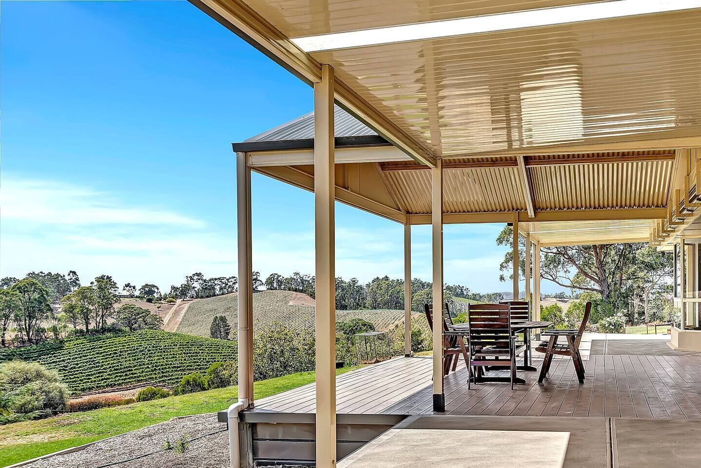 Step onto the covered deck, where outdoor seating invites you to sip local wine while basking in the afternoon sun and picturesque vineyard views.
