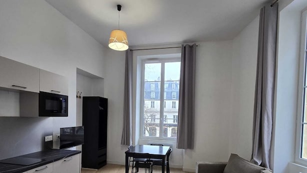 A modern apartment with a kitchen, dining area, and living room. - Studio Grands Boulevards (Paris)