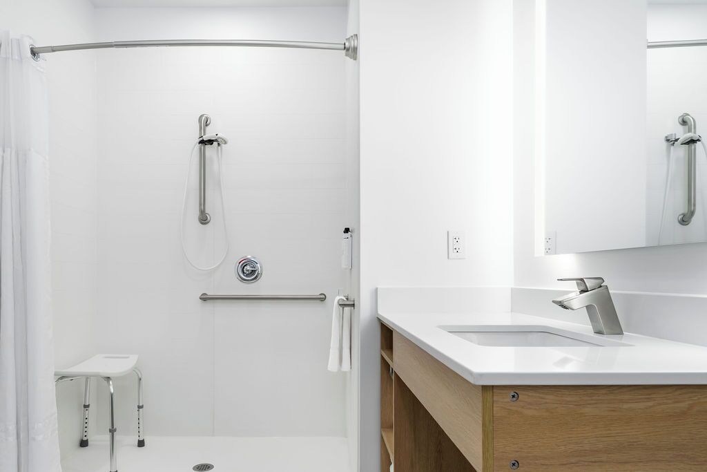 Een moderne badkamer met een douche, een wastafelmeubel en een spiegel.