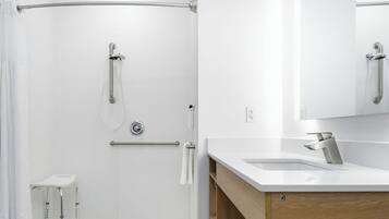 Een moderne badkamer met een douche, een wastafelmeubel en een spiegel.