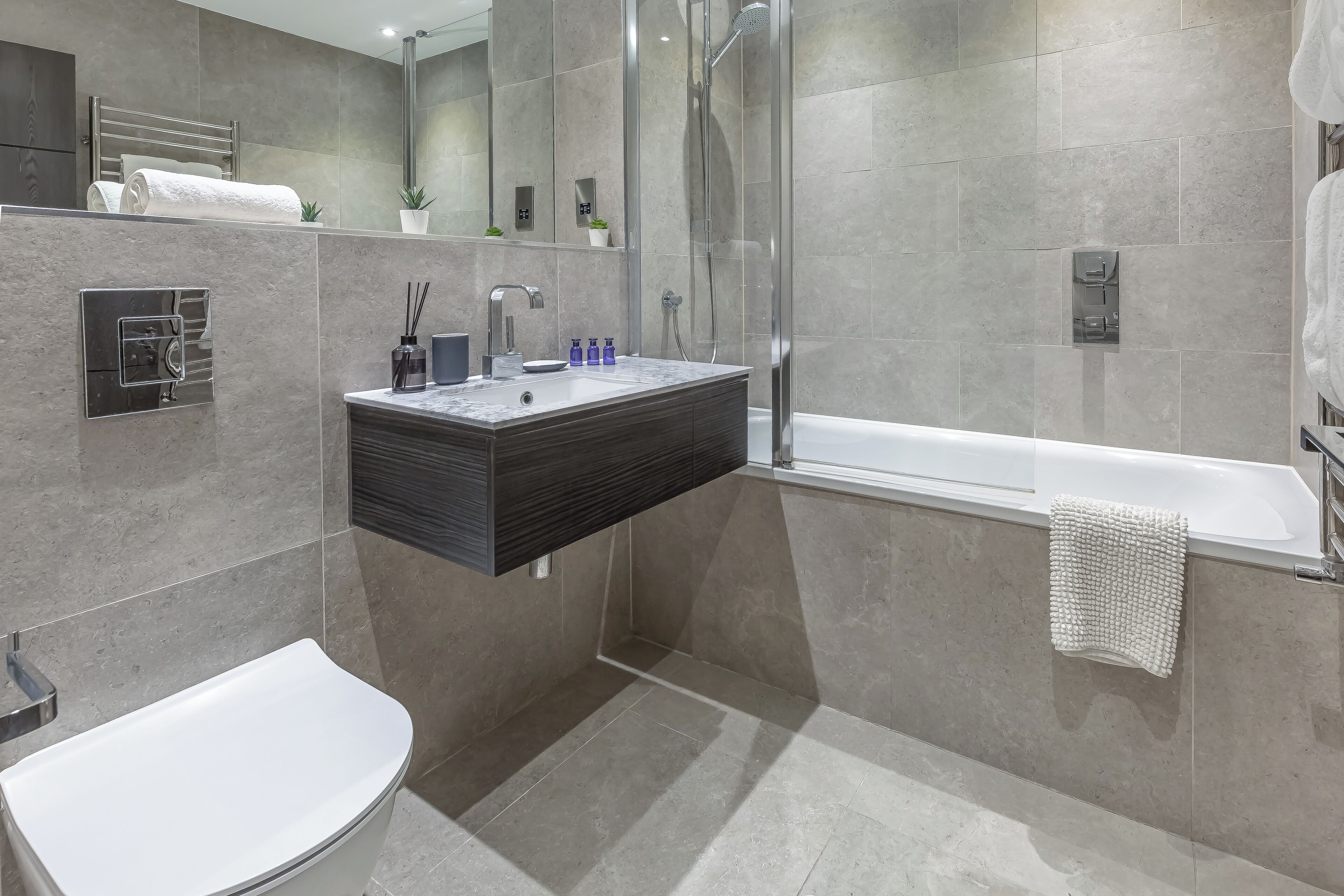 A modern bathroom with a built-in sink, a toilet, and a shower area.