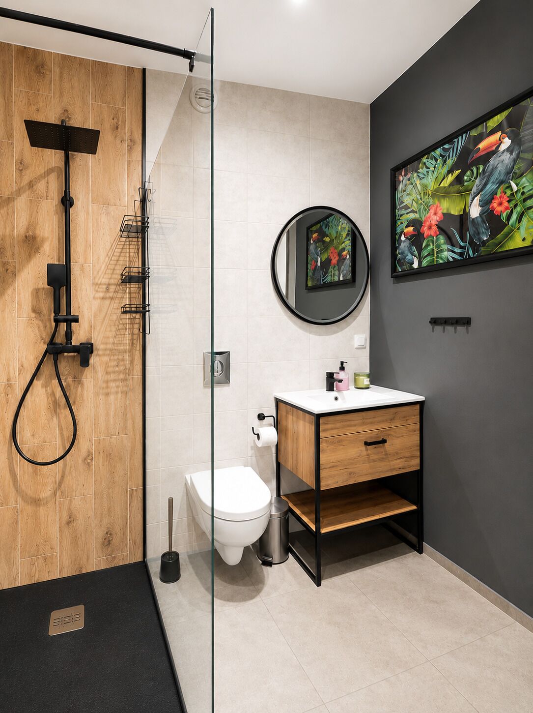 A modern bathroom with a wooden shower enclosure, a toilet, a sink with a mirror, and a framed tropical artwork on the wall.