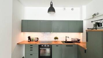 Departamento Confort, vista a la ciudad | Cocina privada | Artículos de limpieza, toallas de papel y comedor