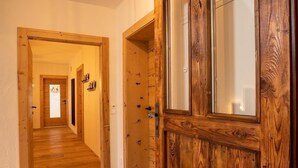 A wooden hallway with a door leading to a room.