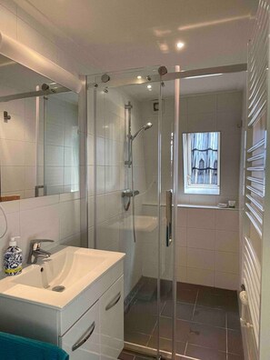 Een douche, een haardroger, handdoeken, shampoo