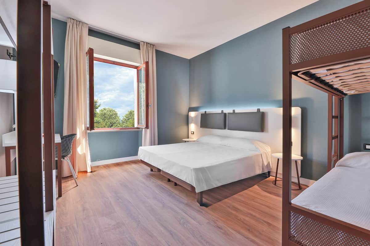 Un dormitorio con una cama grande, un escritorio y una silla.