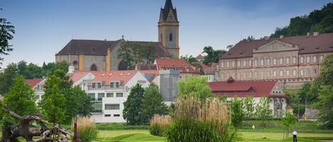 A historic town with a prominent church tower, lush green park, and traditional buildings.