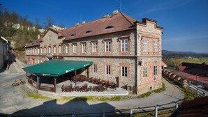 A stone building with a green roof and outdoor seating area. - Residence Knížecí Dvůr (Hluboká nad Vltavou)