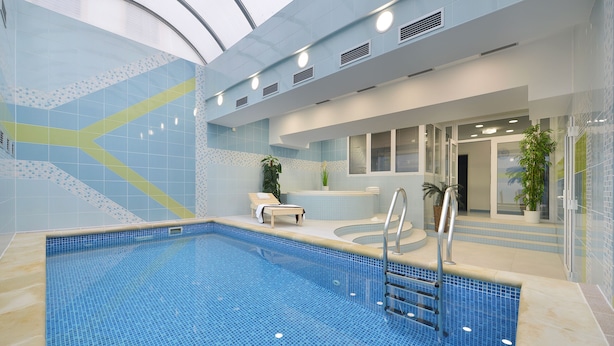An indoor swimming pool with a tiled floor, a ladder, and a seating area with a bench and potted plants. - Residence Knížecí Dvůr (Hluboká nad Vltavou)