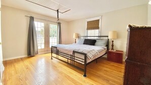 A bedroom with a bed, bedside lamps, a window with a blind, and a radiator. - Spacious 5-bedroom house in welcoming Wilmington with WiFi, AC, Large Yard (Wilmington)