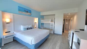 Un dormitorio con una cama litera, un escritorio, una silla, una mesita de noche y una lámpara de pared.