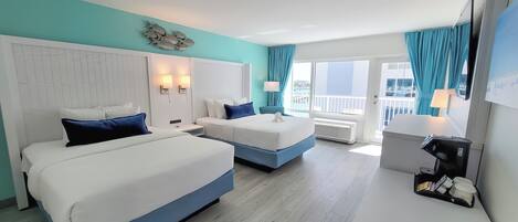 A hotel room with two beds, a large window with a view, a balcony, and a minibar.