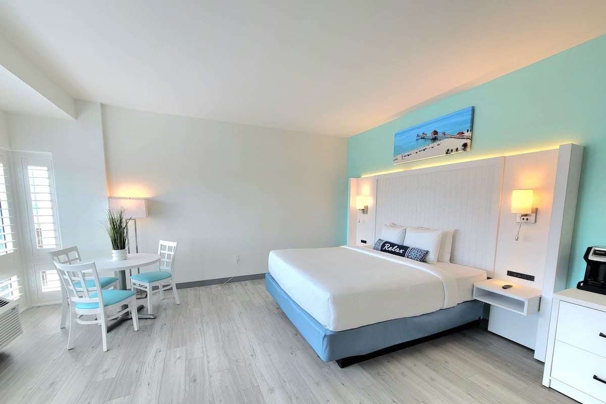 Une chambre d’hôtel moderne, équipée d’un lit, d’un bureau et de chaises.