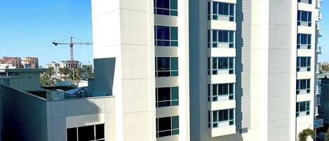 A modern multi-story building with a flat facade, large windows, and a clock on the top.