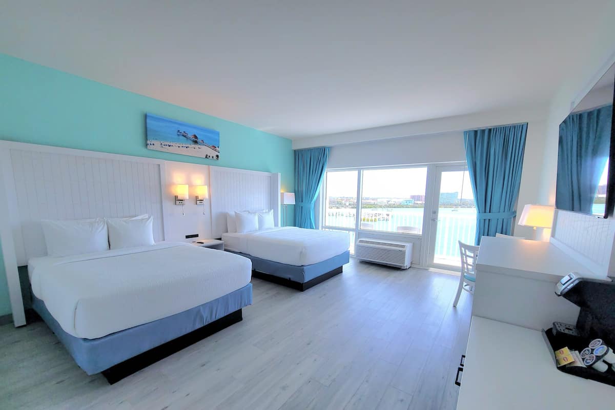 Une chambre d’hôtel avec deux lits, un bureau et une vue sur la ville.