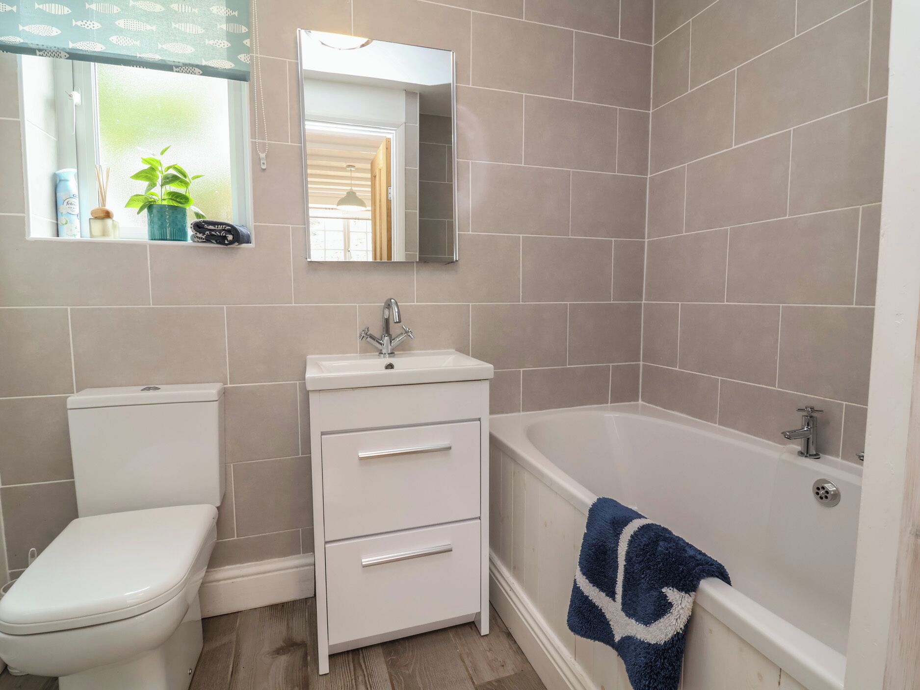 A bathroom with a toilet, sink, and bathtub.
