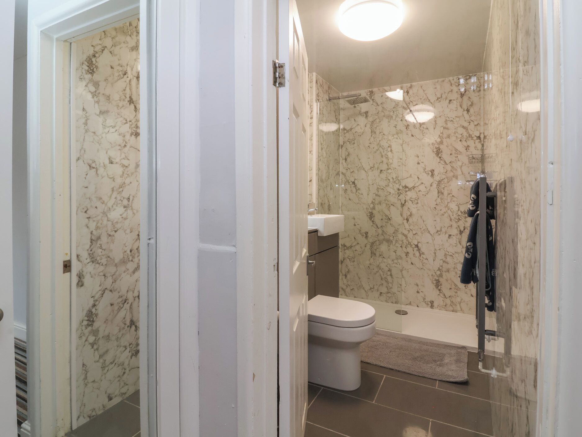 Ein Badezimmer mit Toilette, Dusche und einer Duschkabine.