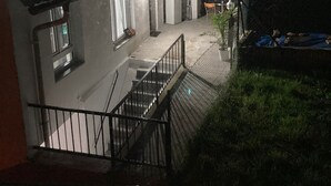 Nachtsicht eines Wohngebiets mit einer Treppe zu einem überdachten Außenbereich.