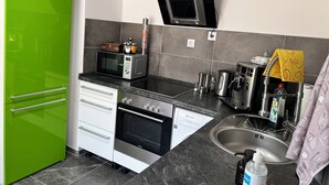 Eine kleine Küche mit Mikrowelle, Backofen und Spüle.