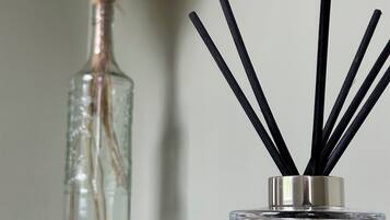 A clear glass diffuser with black reeds and a label indicating it is from Jo Malone London.