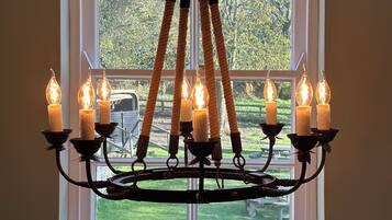 Un candelabro con múltiples velas en una habitación con un ventanal grande.