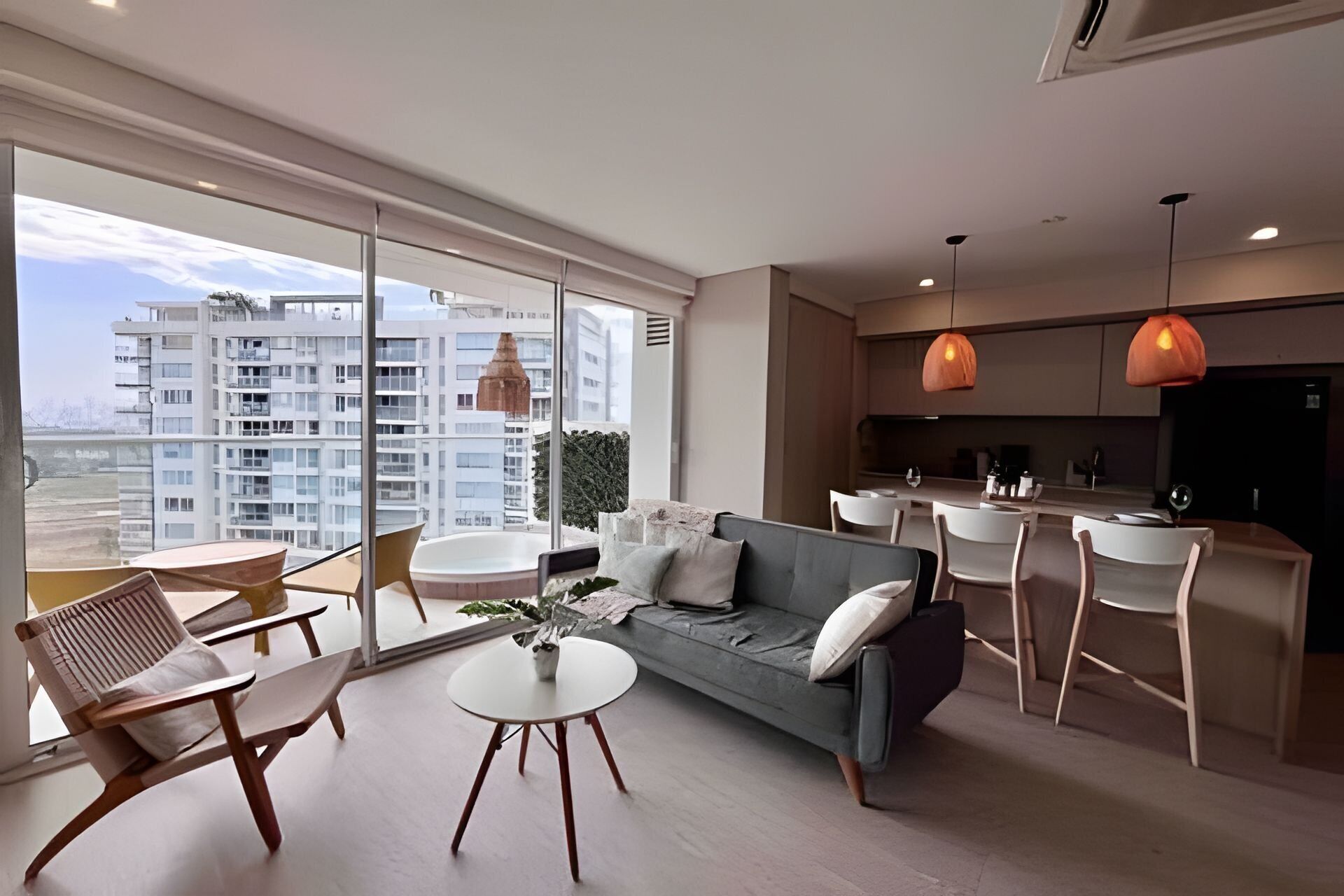 Un apartamento moderno con sofá, mesa de comedor, sillas y zona de cocina.