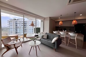 Un appartamento moderno con divano, tavolo da pranzo, sedie e angolo cottura.