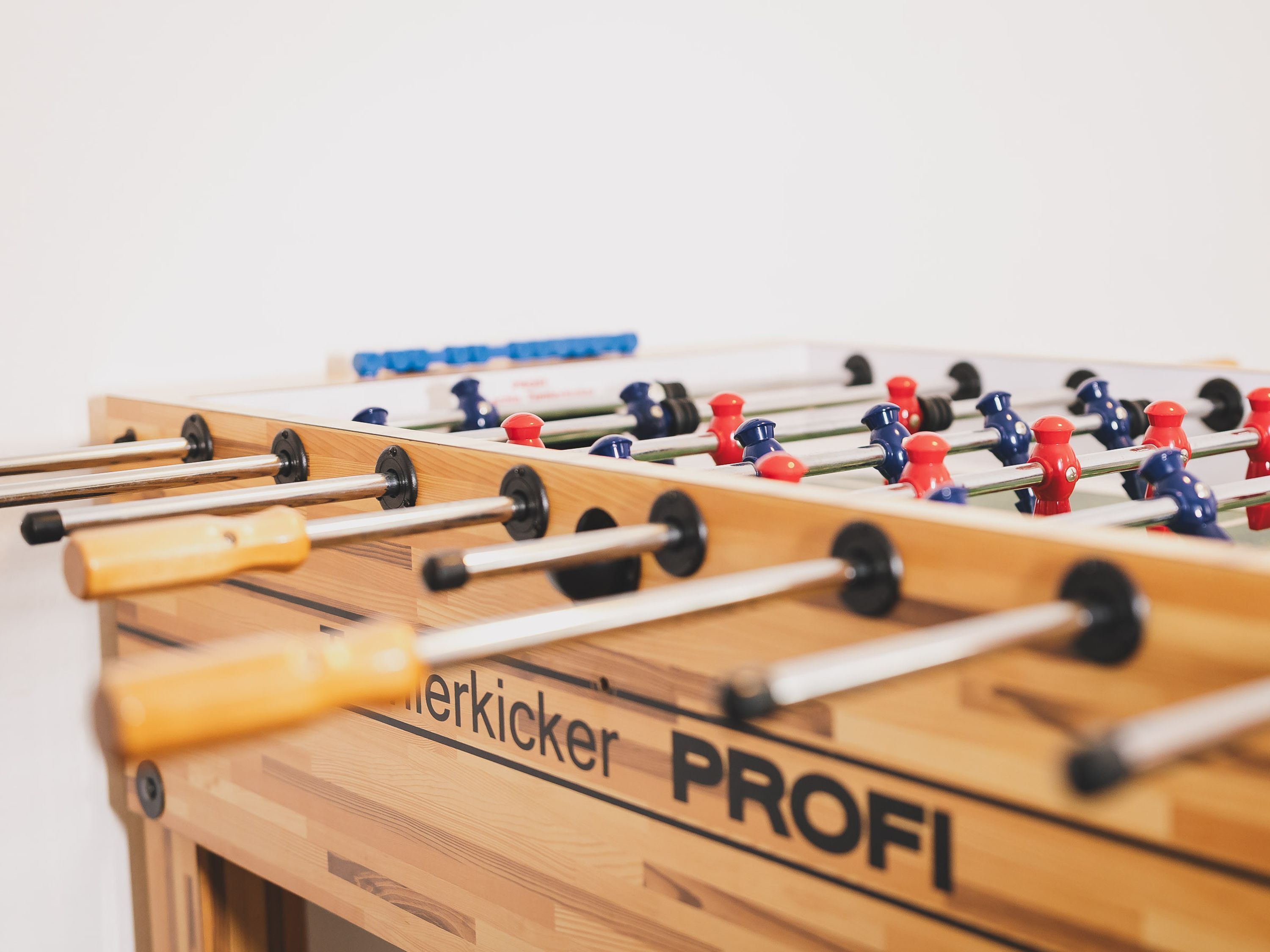 A wooden foosball table with 'PROFI' and 'Herkicker' branding.