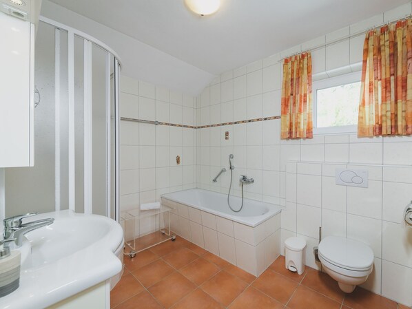 Un baño con ducha, inodoro y lavamanos.