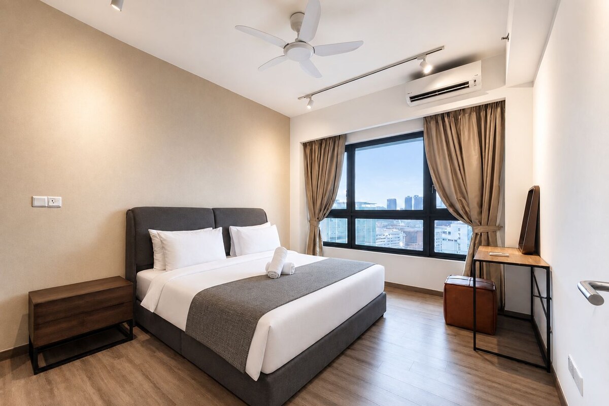 Una habitación de hotel moderna con una cama grande, un escritorio y vistas a la ciudad.