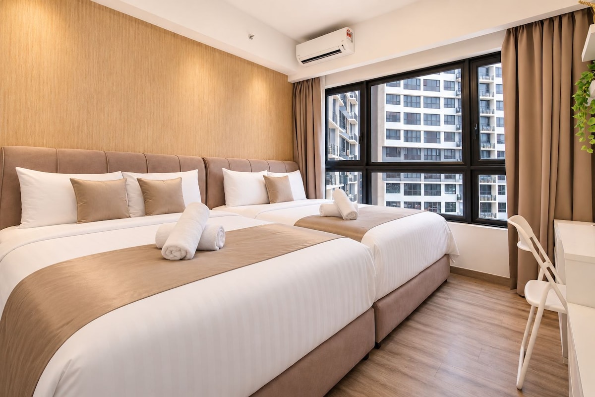 A hotel room with two beds, a large window, and a view of the city.