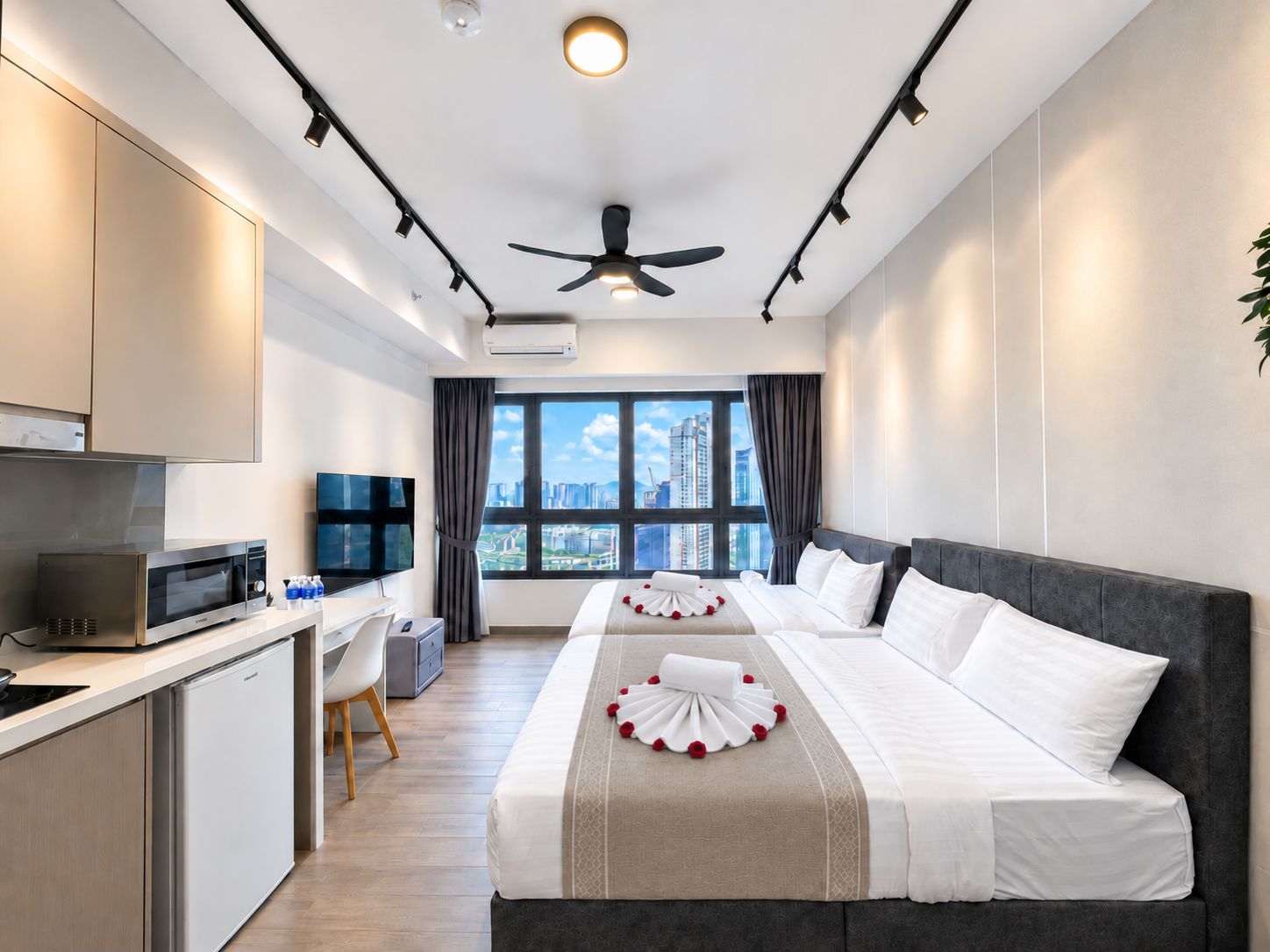 Ein Hotelzimmer mit Bett, Schreibtisch, Mikrowelle und Fernseher.