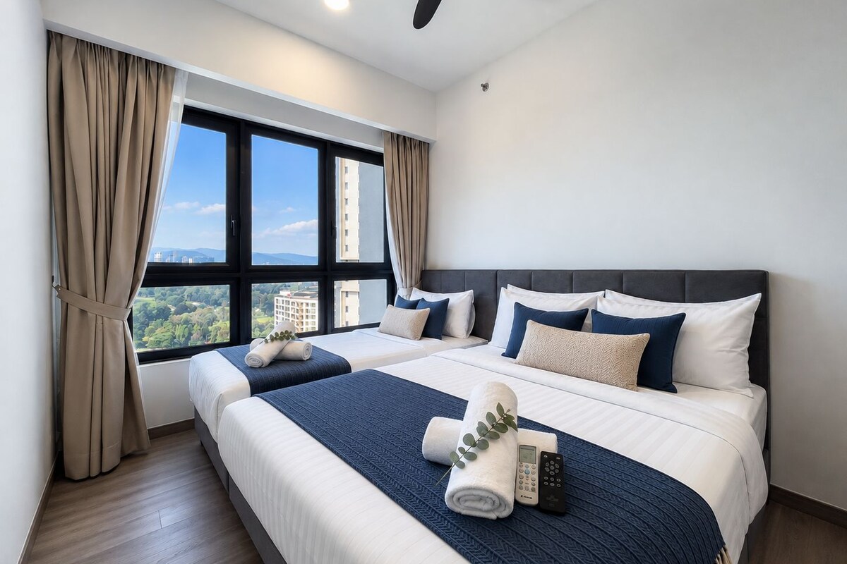 Habitación de hotel con dos camas, un ventanal con cortinas, ventilador de techo y vista a la ciudad.