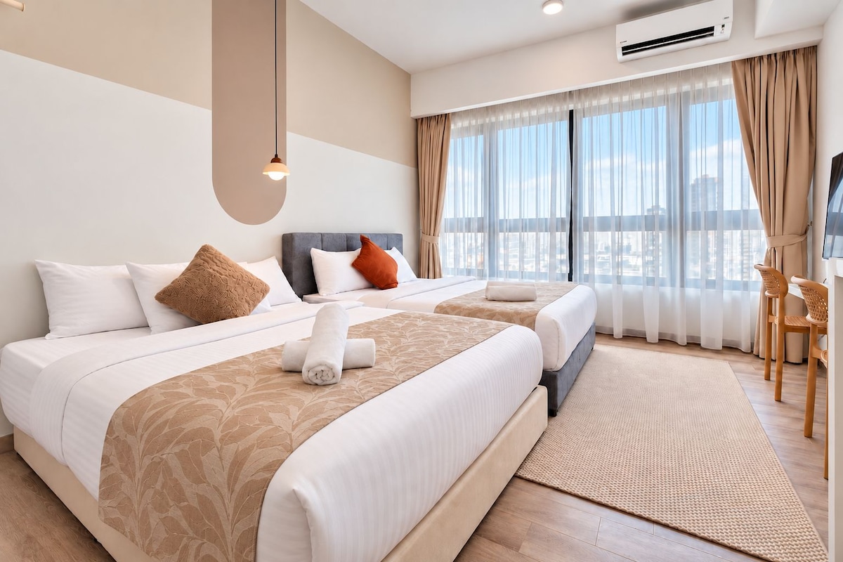 A hotel room with a large bed, a desk, and a view of the city.