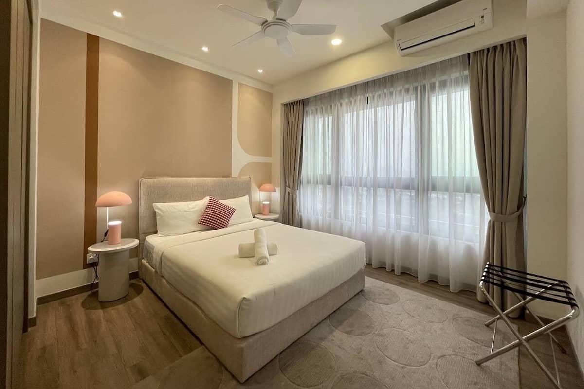 Een moderne hotelkamer met een groot bed, nachtlampjes, een airconditioning en een plafondventilator.