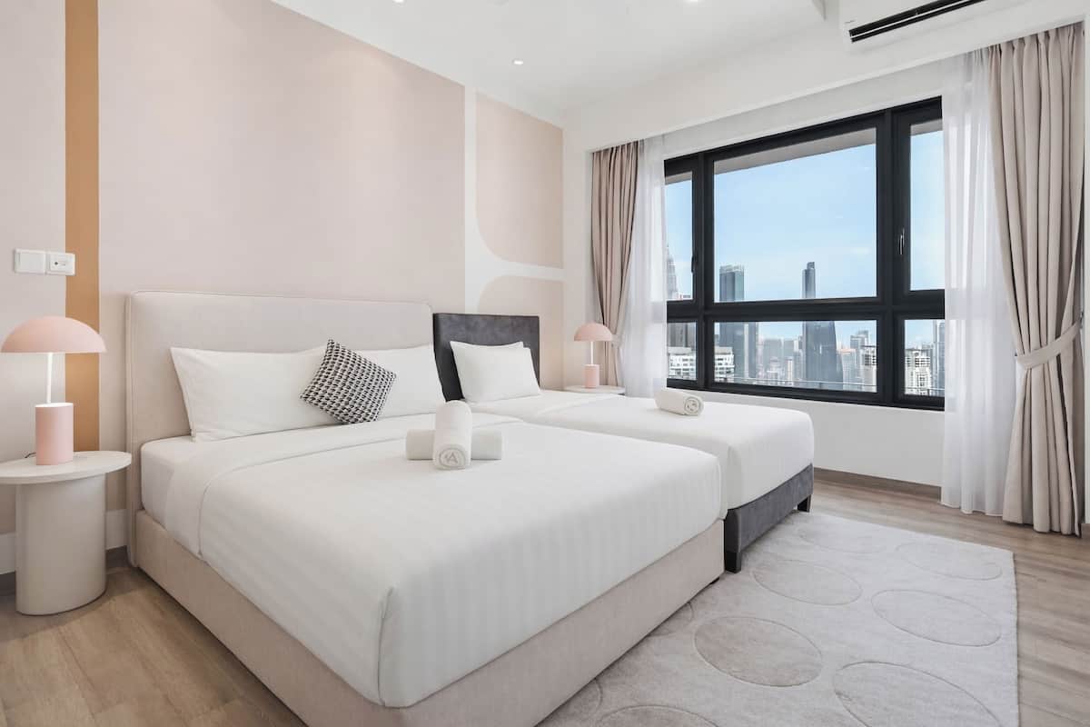 A modern hotel room with two beds, a large window with a city view, and a minimalist design.