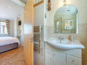 A modern bathroom with a large mirror, a sink, and a towel rack.