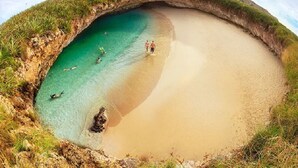 A beach with clear turquoise water, a sandy shore, and a small cave entrance. - Staffed villa in gated community - Punta Mita Corridor (La Cruz de Huanacaxtle)