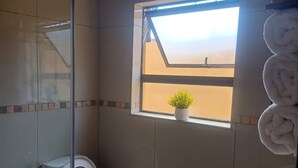 Ein Badezimmer mit Toilette, Waschbecken und einem Fenster mit Blick.