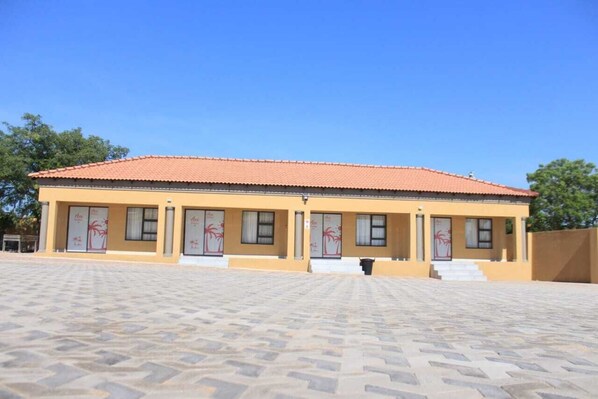 Un edificio con techo de tejas y patio empedrado.