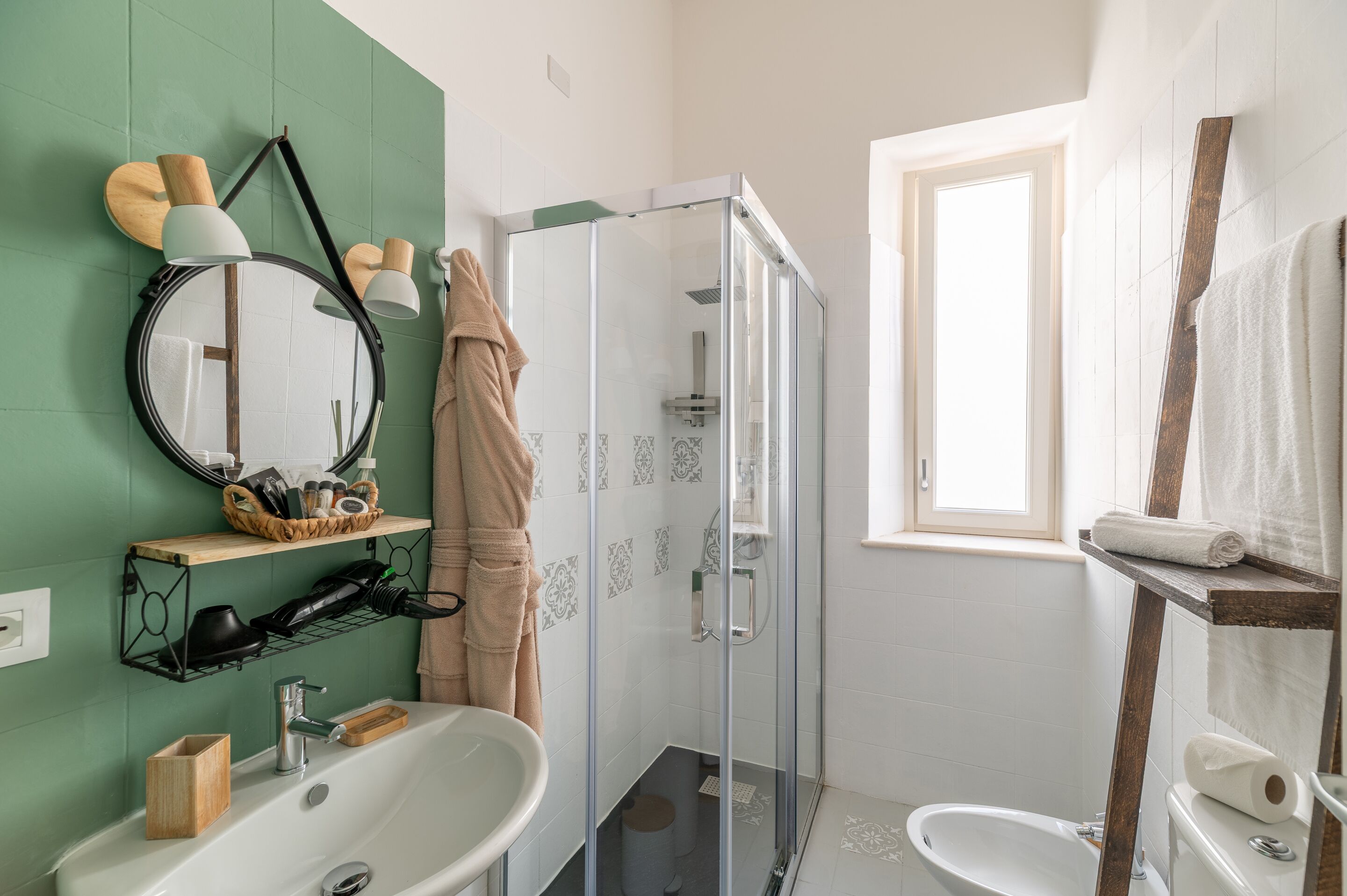 A bathroom with a bathtub, a shower, a toilet, a sink, a mirror, and a window.