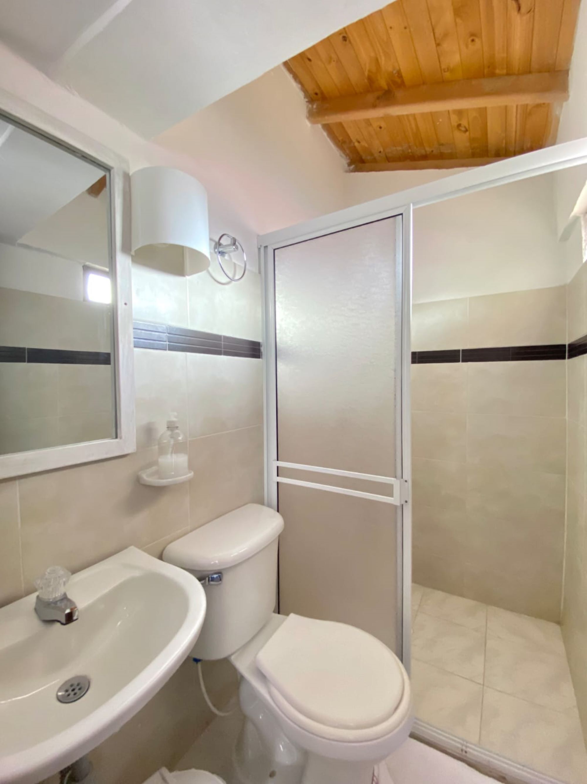 A bathroom with a toilet, sink, and shower.