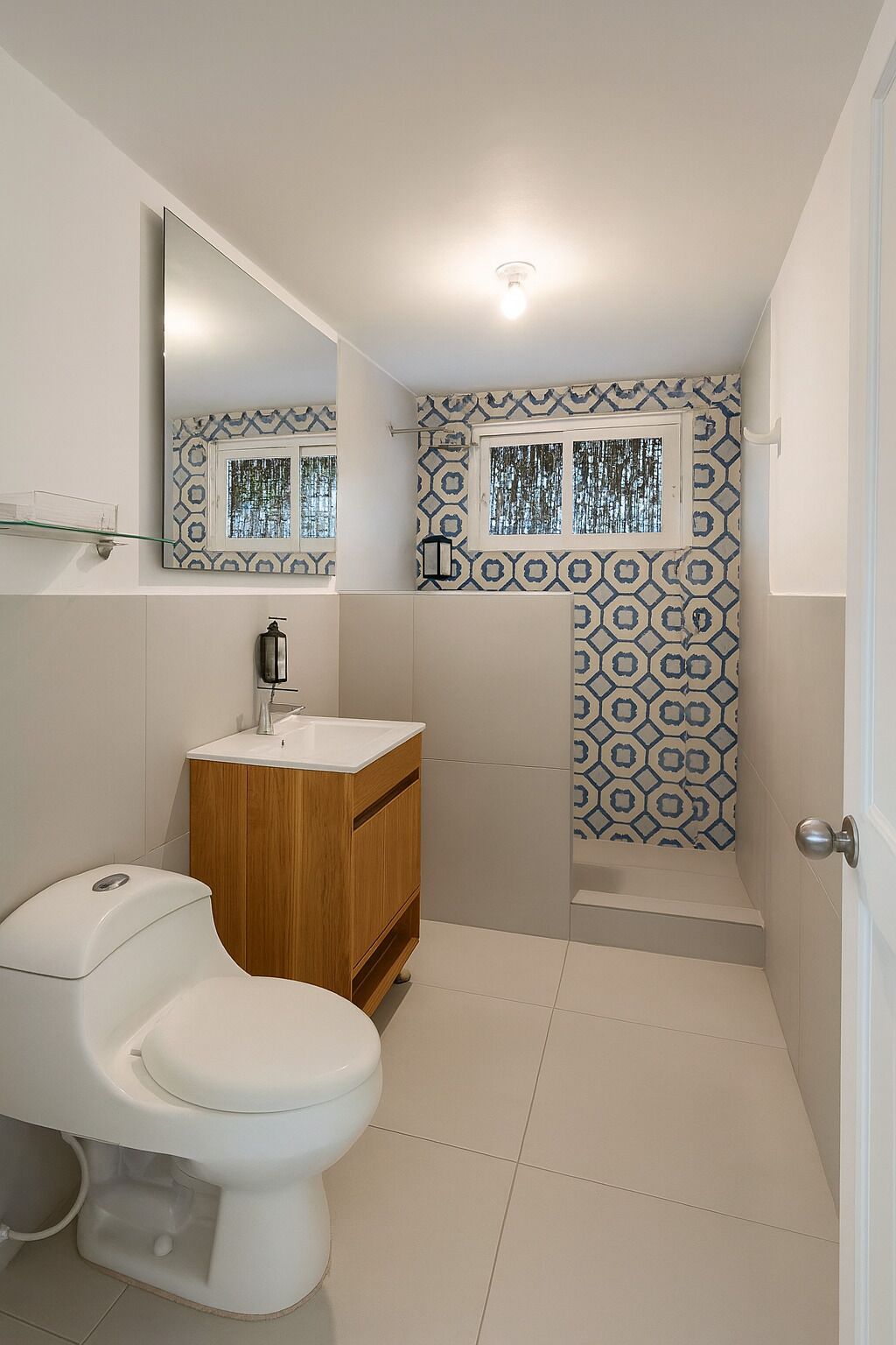 Une salle de bain avec des toilettes, un lavabo et une douche.