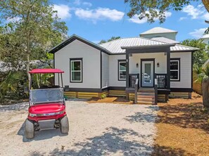 A single-story house with a porch, a garage, and a small driveway. - New List-Golf Cart Included Charming 2BR/2BA (Santa Rosa Beach)