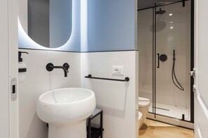 Deluxe appartement | Badkamer | Een haardroger, handdoeken, shampoo, toiletpapier