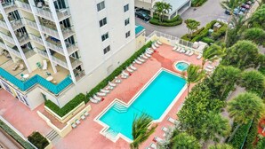 Ein Hotel mit Dachpool, mehreren Balkonen und einem angelegten Garten.