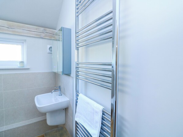 A modern bathroom with a sink, mirror, and towel rack. - Oakleigh (Totnes)