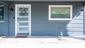 A house with a white front door, a small window with blinds, and a wreath hanging on the door. - Spacious 4BR Home, Central Georgetown Location! (Georgetown)