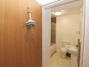 Une salle de bain avec des toilettes, un lavabo et une douche.