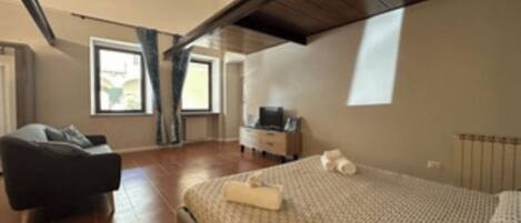 A bedroom with a bed, a chair, a dresser, and a window.